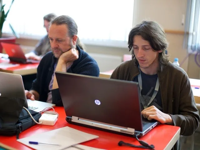 Fejlesztő kódot ír a laptopján egy modern irodai környezetben